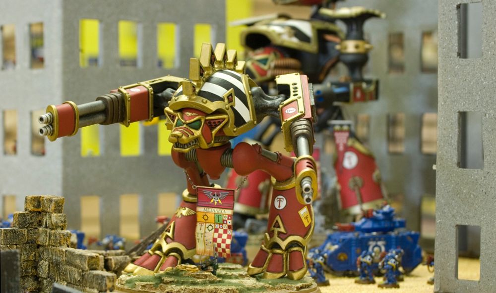 Warhammer 40K: A loyalist Warhound scout titan advanced ahead of an Ultramarines armored column and supporting Reaver titan during the Horus Heresy. 