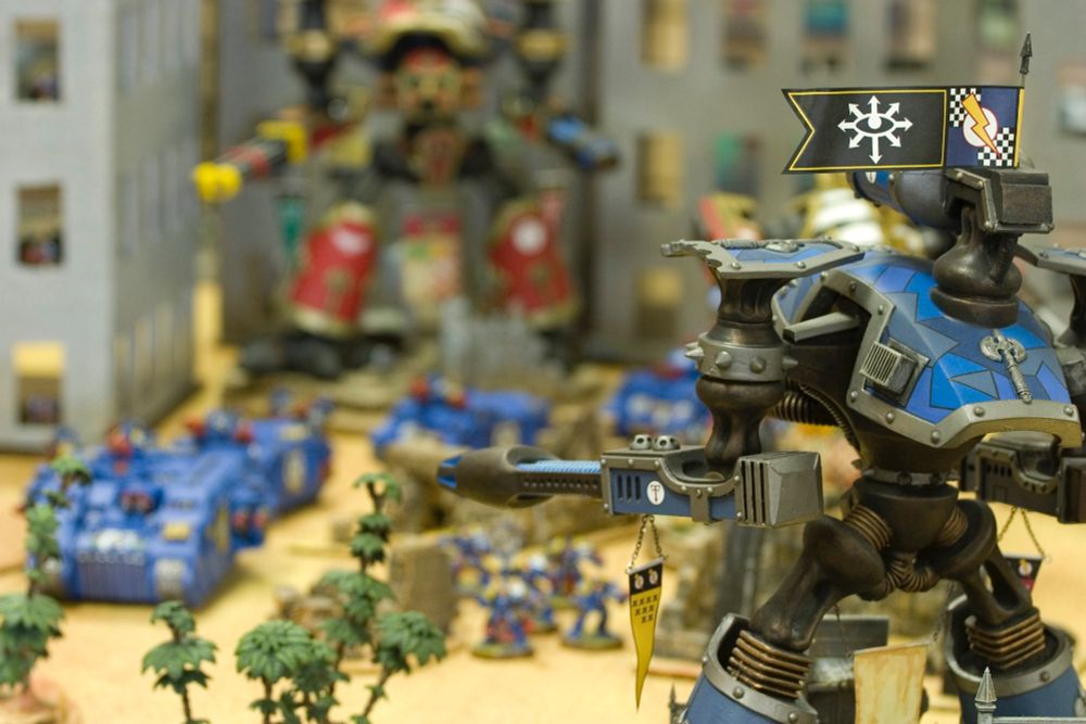 Warhammer 40K: two Reaver titans face off with Ultramarines armored column in between during the Horus Heresy. 