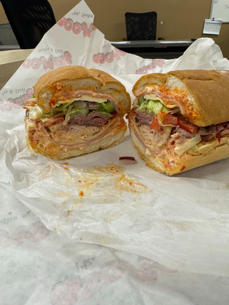 Big sandwich ham turkey roast beef liquids wax paper. 