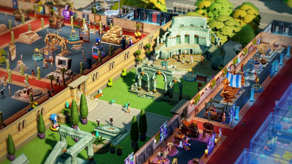 A lovely green courtyard with trees and fancy hedges, Wetlanteon ruines are displayed on top of the grass, including a ruined ampitheatre and ruins of archways.