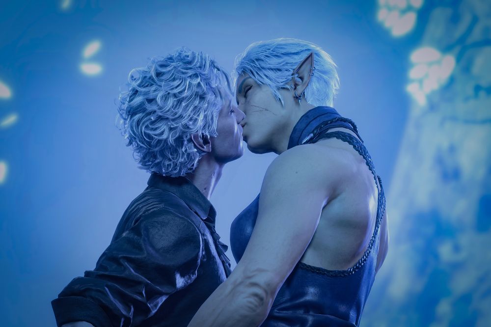 Virtual photography of Astarion and Lumina (Tav) under the Sussur tree in the Underdark, kissing. He reaches up while she leans down to meet his lips, while holding hands just outside of the image.

Astarion is wearing his usual camp clothes dyes black and Lumina is wearing the leather garb dyed boreal blue. 