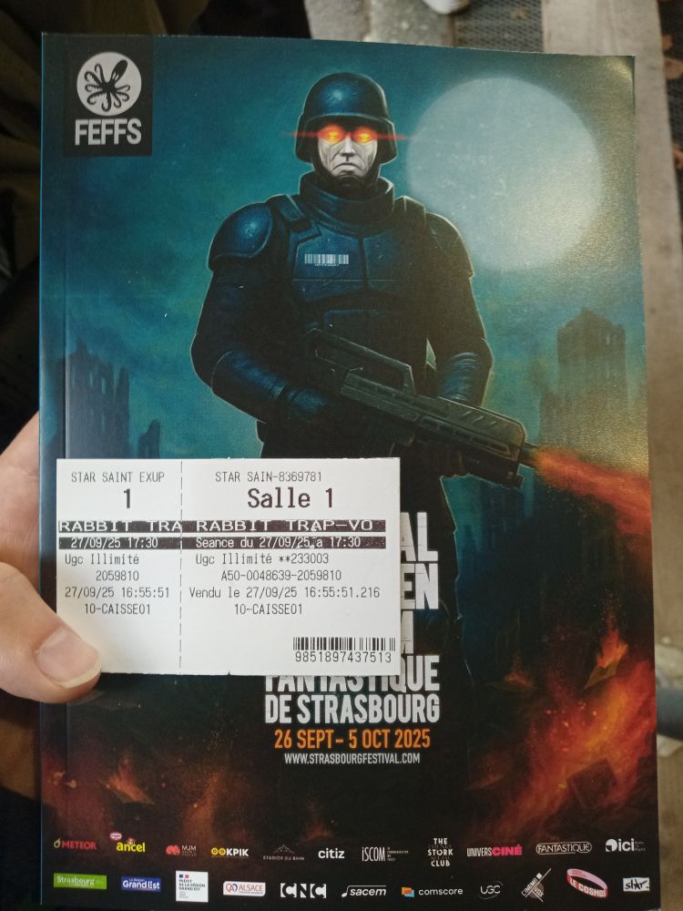 Mon pouce qui tient le combo ticket pour The Rabbit Trap (notre premier film du festoche)+programme dudit festoche en grand format.