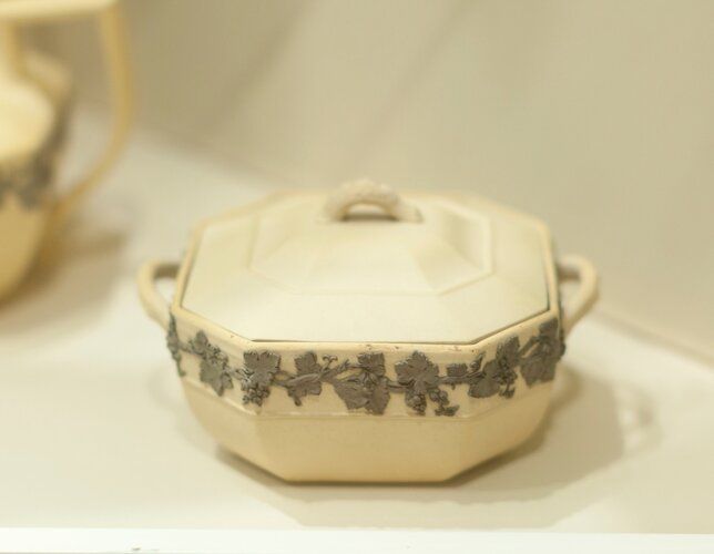 Covered sugar bowl, buff colored cane ware with band of grapevine design in relief, octagonal shape, ceramic, English, XIXc cat. card dims 3 x 4-1/2 x 5-1/2'; needs to be renumbered (says 'a' and 'g')