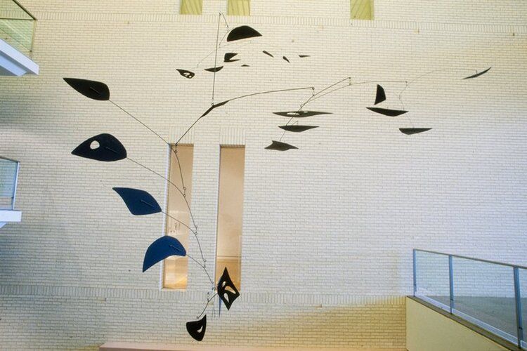 hanging painted metal mobile; comprised of a series of bent steel rods (5 distinct gauges ranging from 1/8" to 5/8") with aluminum-alloy (est) sheet metal paddles and one steel paddle of varying sizes; the components are assigned letters from a-f in order of installation; "a" has one paddle and two rods; ceiling anchor point is at the middle of the primary rod; paddle is incised "UPPER" on the top side; "b" is a single rod; "c" has eight paddles and seven rods; "d" has seven paddles and six rods; "e" has three paddles and three rods, staggered; the paddles are incised "5," "6," and "7; also "Ahab", artist's initials, and year are incised onto paddle "6;" "f" has four paddles and three rods, and a hanging u-shaped element; paddles are incised "1," "2," "3," and "4;" the lowest hanging paddle is steel and the number is punched into the surface with awl or similar tool; the components are connected to one another with a series of rings, S-hooks, and rivets, allowing movement when the mobile is suspended; all parts of the mobile are painted with black matte paint
From childhood Alexander Calder enjoyed inventing mechanical toys and gadgets. In Paris during the 1920s and 1930s he encountered a new type of sculpture, pioneered by Picasso and the Russian Constructivists: assemblages of wood, metal, plastic, and cardboard, with space incorporated as part of the design. Calder began building similar abstract pieces in 1930 but gave them a new dimension--motion. Fellow artist Marcel Duchamp christened the moving sculptures "mobiles." One of Calder's largest mobiles, Ahab is composed of three arcs made of steel rods and irregularly shaped disks that suggest natural forms. The title refers to the maniacal sea captain who pursued the white whale in Herman Melville's novel Moby Dick (1851).