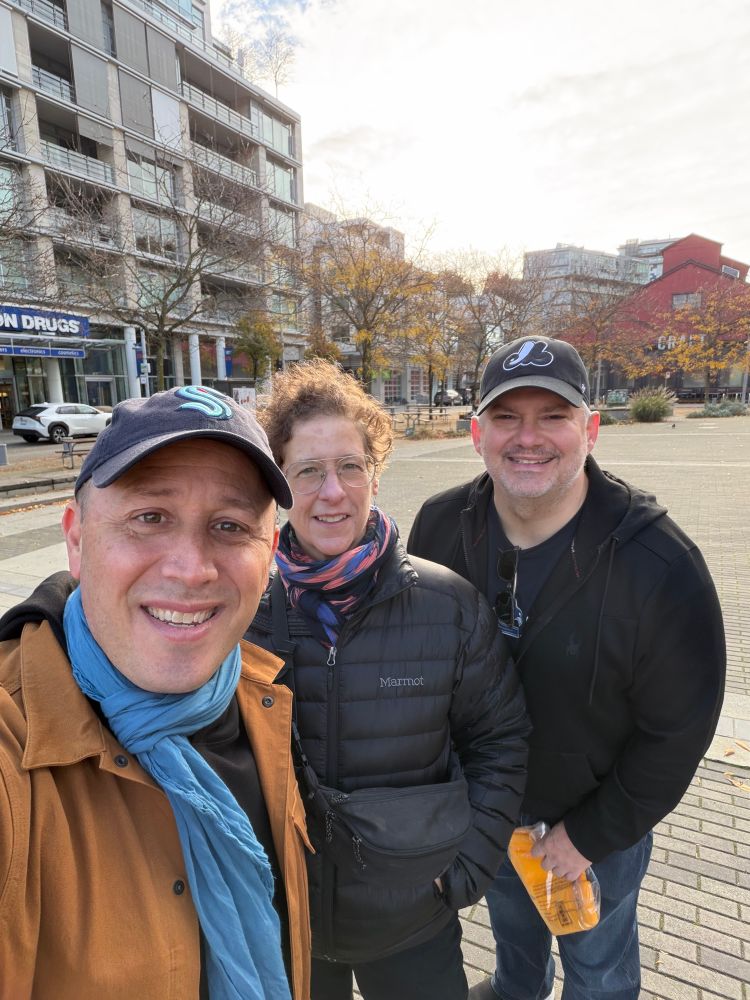 Doug Gordon in baseball cap, blue scarf and brown jacket, Sarah Goodyear and colorful scarf and black jacket, Brent Toders  in black jacket and ball cap