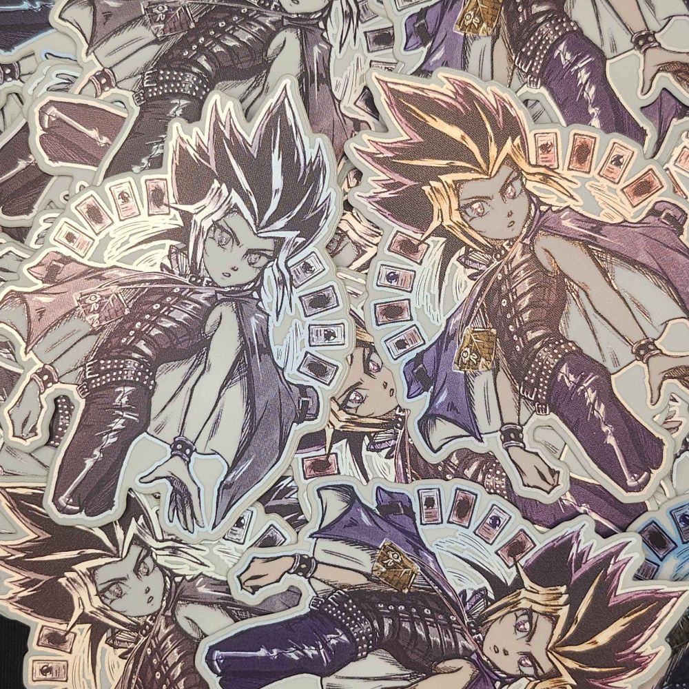 A pile of stickers that depict Yami-Yugi from yu-gi-oh duel monsters with his early season/manga belted outfit and 8 cards surrounding him as he looks at the viewer. This image shows that the stickers come in both color and black and white variants. A light is cast to show that they are shiny.