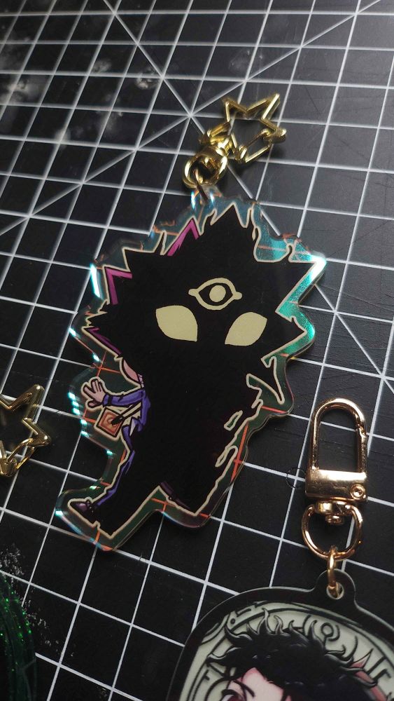 the back of a yugioh season 0 fan charm showing yami yugi is the distorted shadow behind yugi