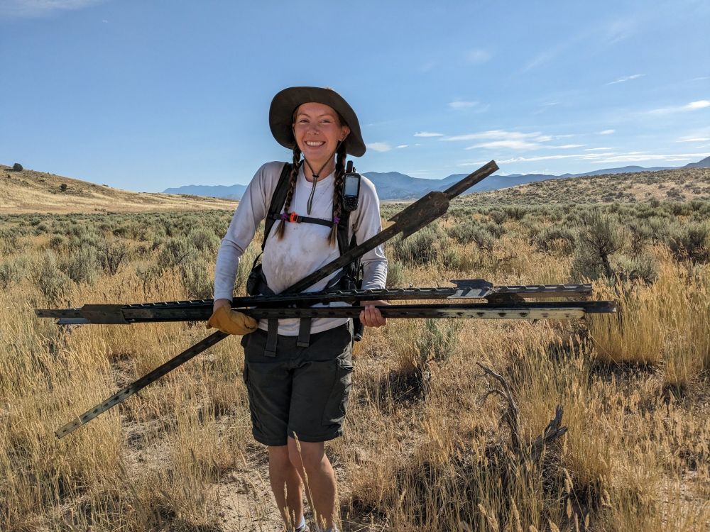 Camille carrying fenceposts from tear down of bear coral.