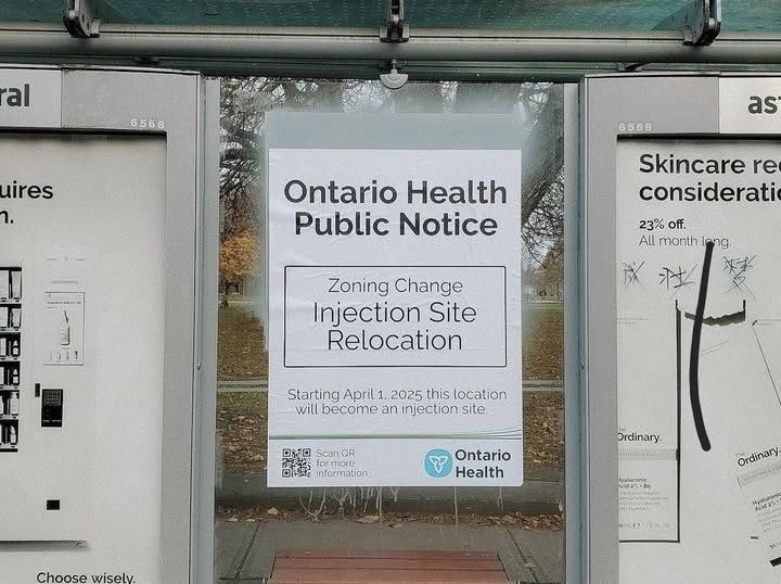 Street photograph of a bus stop with a poster which reads “Ontario Health Public Notice. Zoning Change. Injection Site Relocation. Starting April 1, 2025 this location will become an injection site.” 