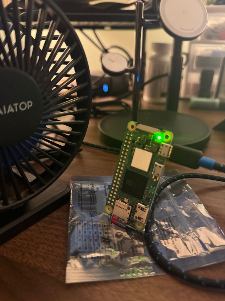 Picture of a Raspberry Pi Zero 2 w on a static proof bag with a  fan blowing on it 