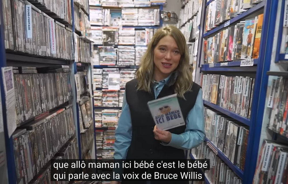 Lea Seydoux holding a copy of "Look Who's Talking," a film she chose over, say, "The Sorrow and the Pity," or something else that denotes good taste 