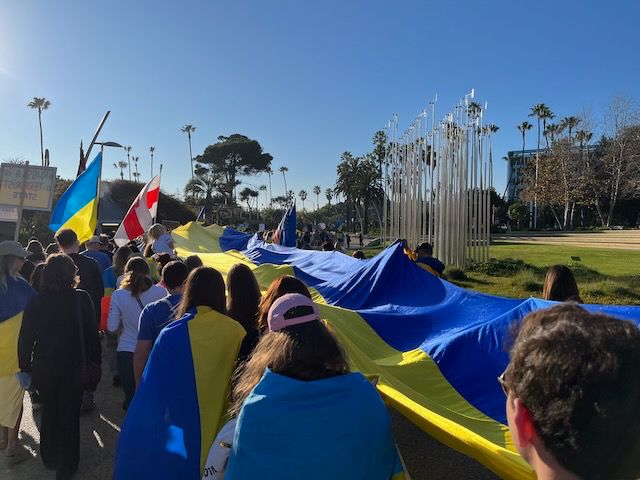 Rally participants carrying a 100-ft/30m UKR flag through Santa Monica toward the pier