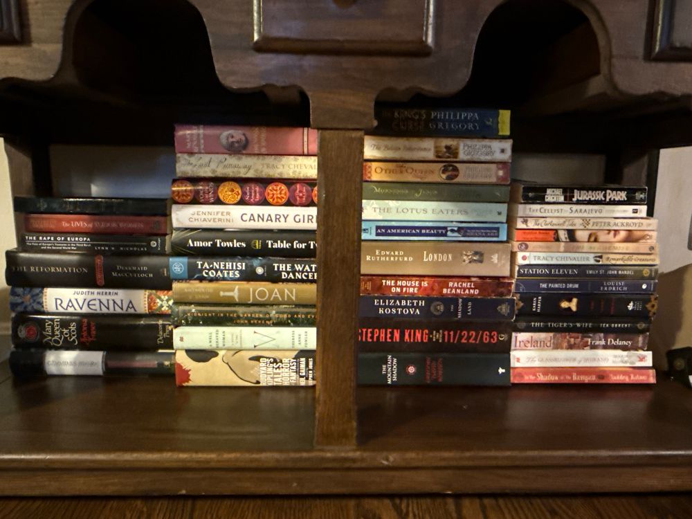 (4) stacks of used books with spines facing outward 