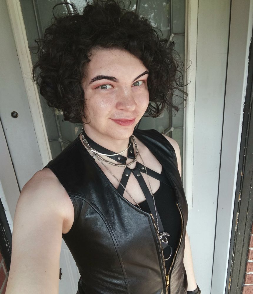 Me with my hair dyed black, leather vest, harness, and necklaces.