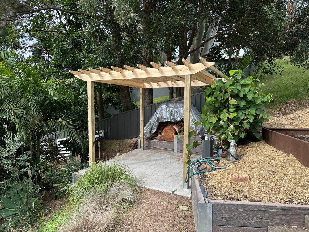 A wooden pergola in a garden. 