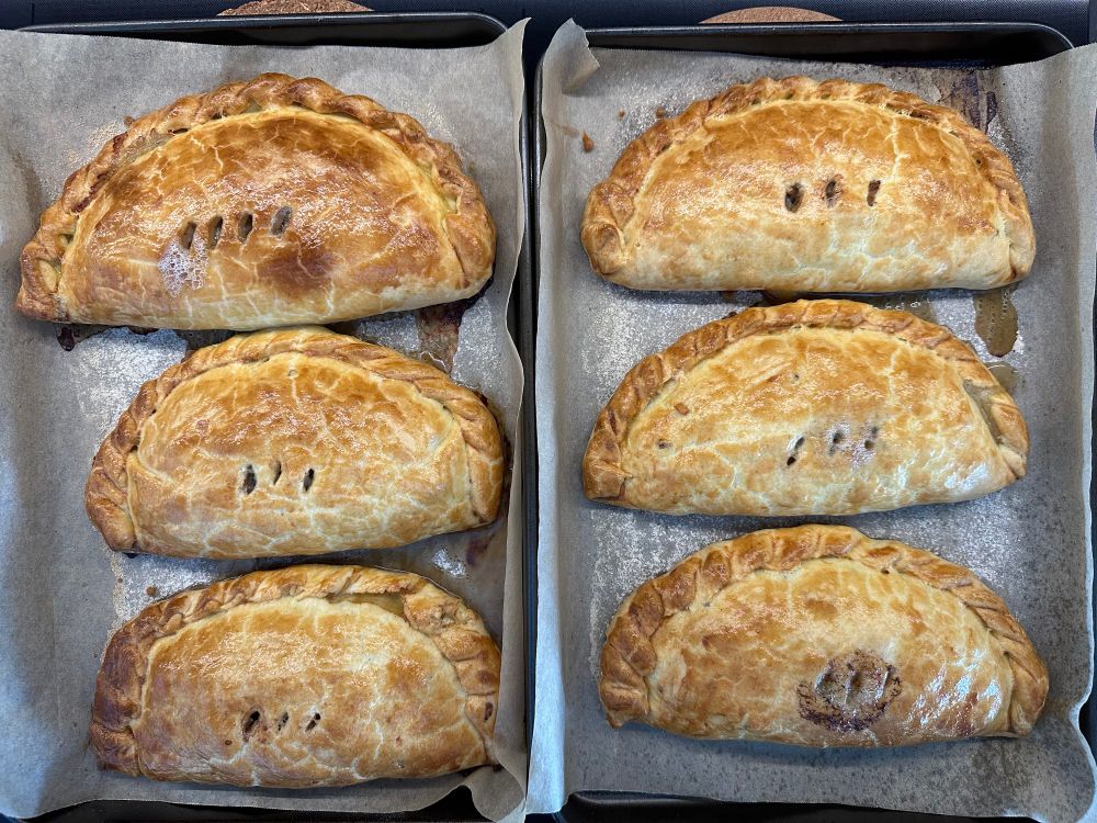 Six freshly cooked Cornish pasties. 