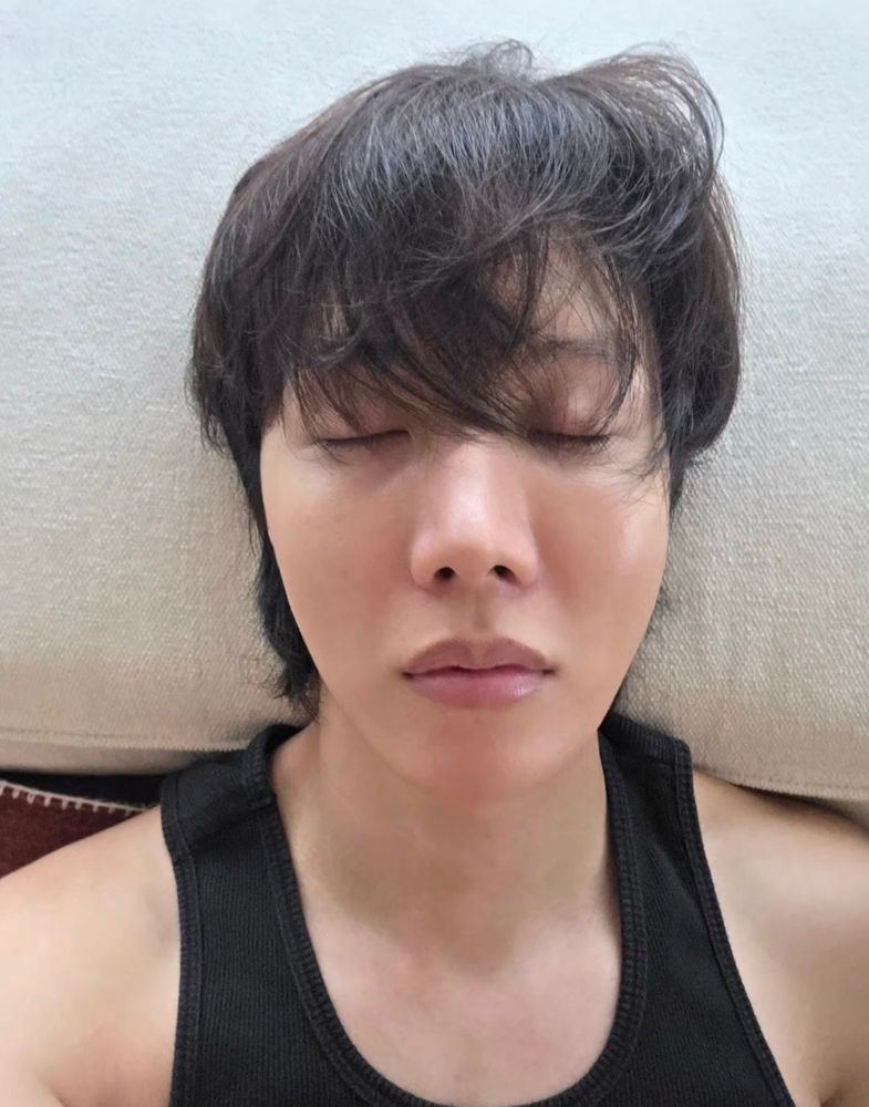 BTS j-hope selfie with closed eyes and tousled hair. He’s wearing a black tank top. And his lips… so tempting 