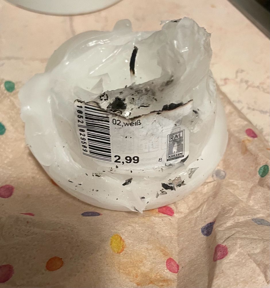 Kerze in angekokelter Plastikfolie. 