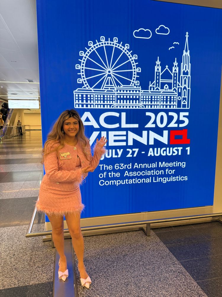 I’m wearing a pink suit with a fur trim and pink heels with big bows in the middle while smiling in front of the ACL sign inside the conference hall