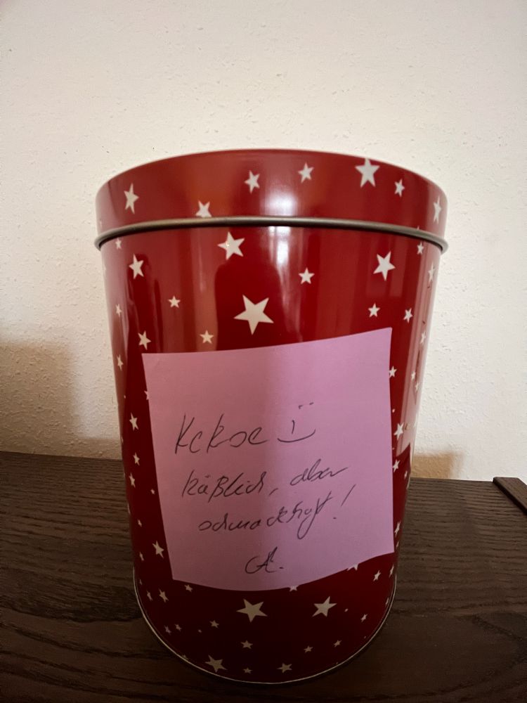 Eine Keksdose, auf der einen Zettel klebt
„Kekse. Hässlich, aber schmackhaft“