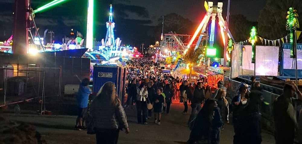 A carnival at night, filled with people 
