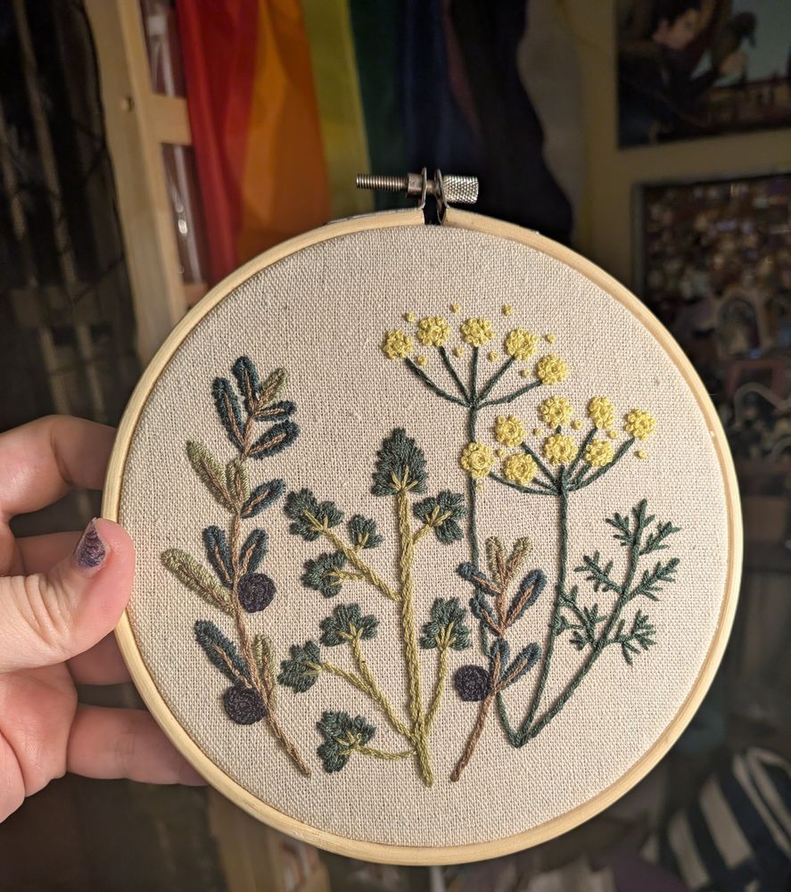An embroidery project of several herbs on beige fabric