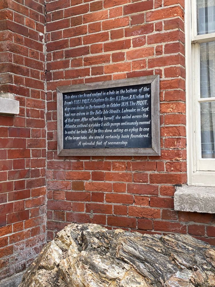 A plague on a brick wall reads ‘This stone was found wedges in a hole in the bottom of the Frigate HMS PiQUE C. Captain the Hon H.J Rous R.ND when the ship was docked in Portsmouth in Oct 1835. The PIQUE had run ashore in the Belle Isle Straits, Labrador, in Sept of that year. After refloating herself she sailed across the Atlantic without a rudder & with pumps continuously manned to control her leaks. But for this stone, acting as a plug to one of the larger holes, she would certainly have foundered.
A splendid feat of seamanship.’