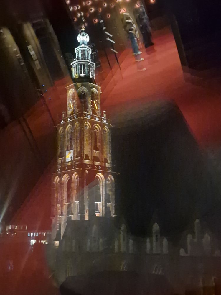 Martinitoren door een raam van het Forum gekiekt.