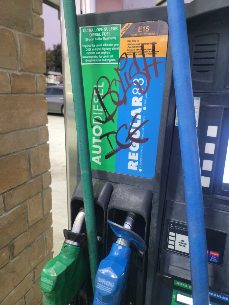 A gas station pump with the words abolish ice written on it.