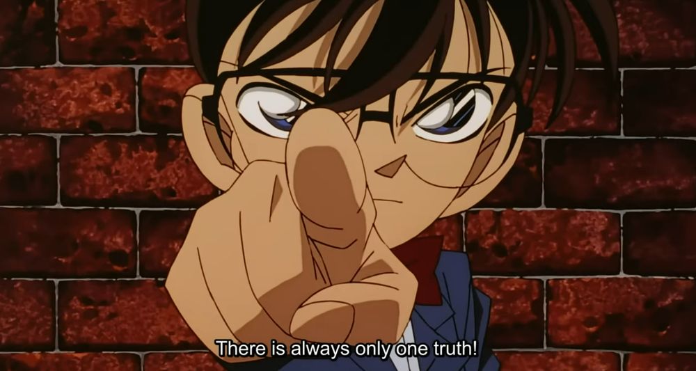 Conan in his classic pointing pose, "There is only one truth." Conan is a child detective with glasses, bowtie, and a blue blazer.