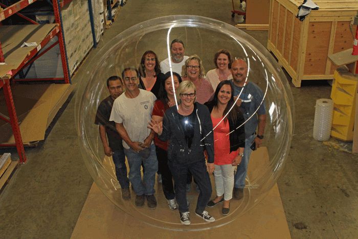 10 people are smiling at all of us they are inside a plastic sphere