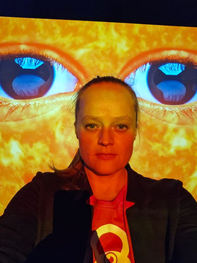 Theresa vor einer Großaufnahme von "Genossin Sonne" der gleichnamigen Ausstellung