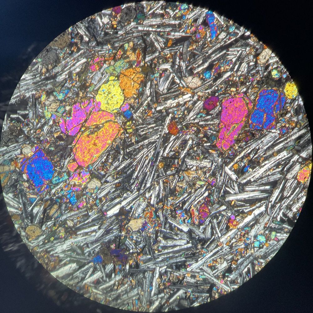 Cross polarised light view of basalt with large olivine phenocrysts, elongate plagioclase laths and interstitial clinopyroxene.