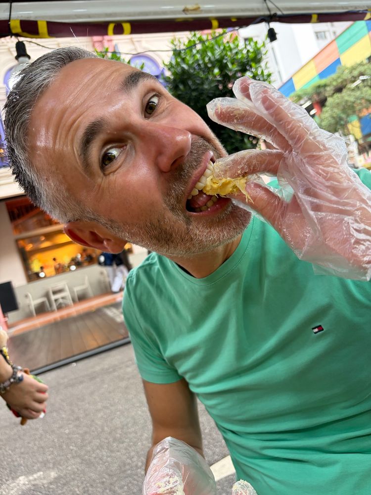 Keith eating durian, gloved to avoid smelly fingers. 