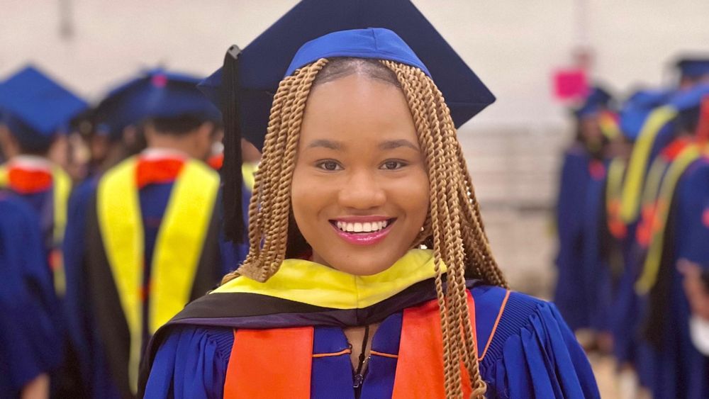 Precious Olalere smiling in her cap and gown. 