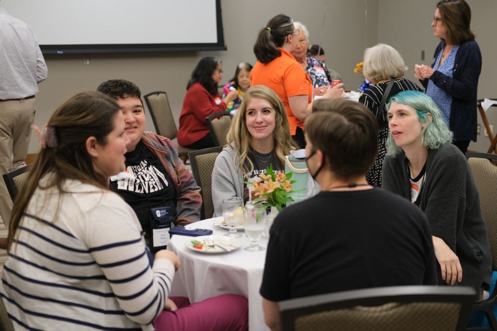 Attendees sitting at their tables and mingling at the iSchool Alumni Reception at the I Hotel.