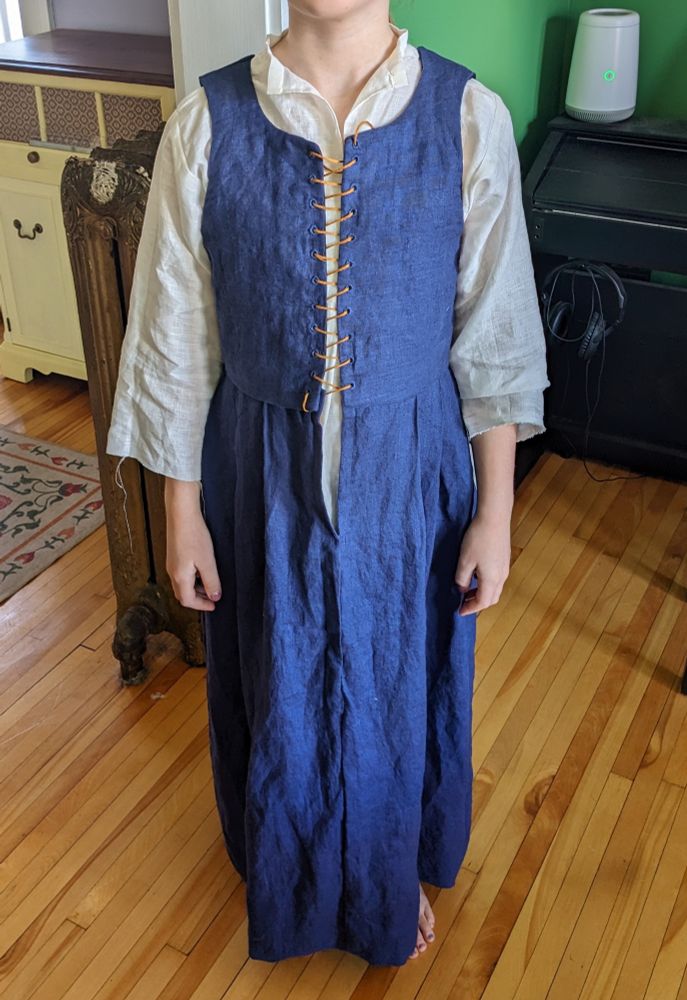 A child wearing a pretty decent 16th century blue linen kirtle with white smock underneath.