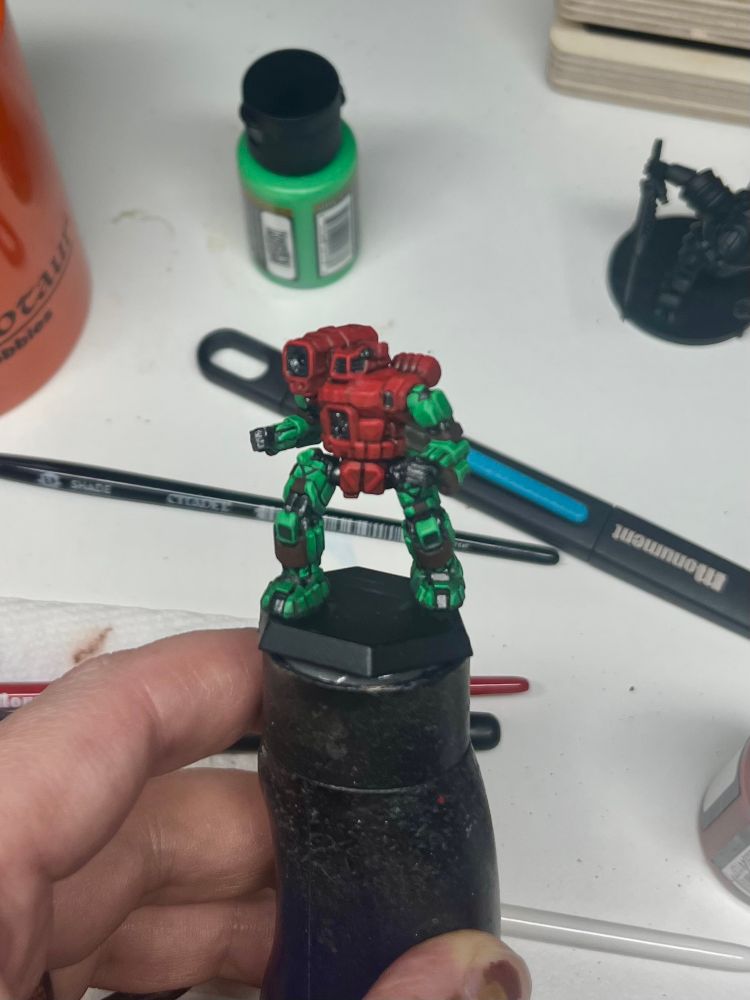 Front left 3/4 image of work in progress Hunchback. The red torso and green limbs are complete and the metallic areas are put in with shading, still awaiting highlights. A base layer of mahogany is laid in for the sections that will be orange. 