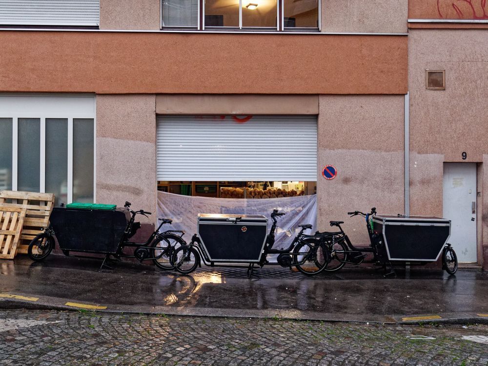 Trois vélos cargos devant un entrepôt/garage entrouvert