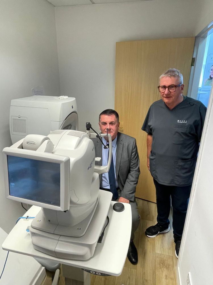 Councillor Stephen McCabe being shown optometry equipment by Frank Munro