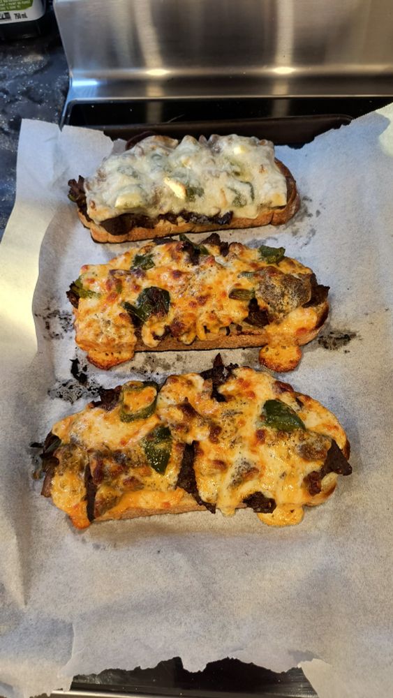 Open-faced cheesesteaks fresh out of the oven before assembly. 