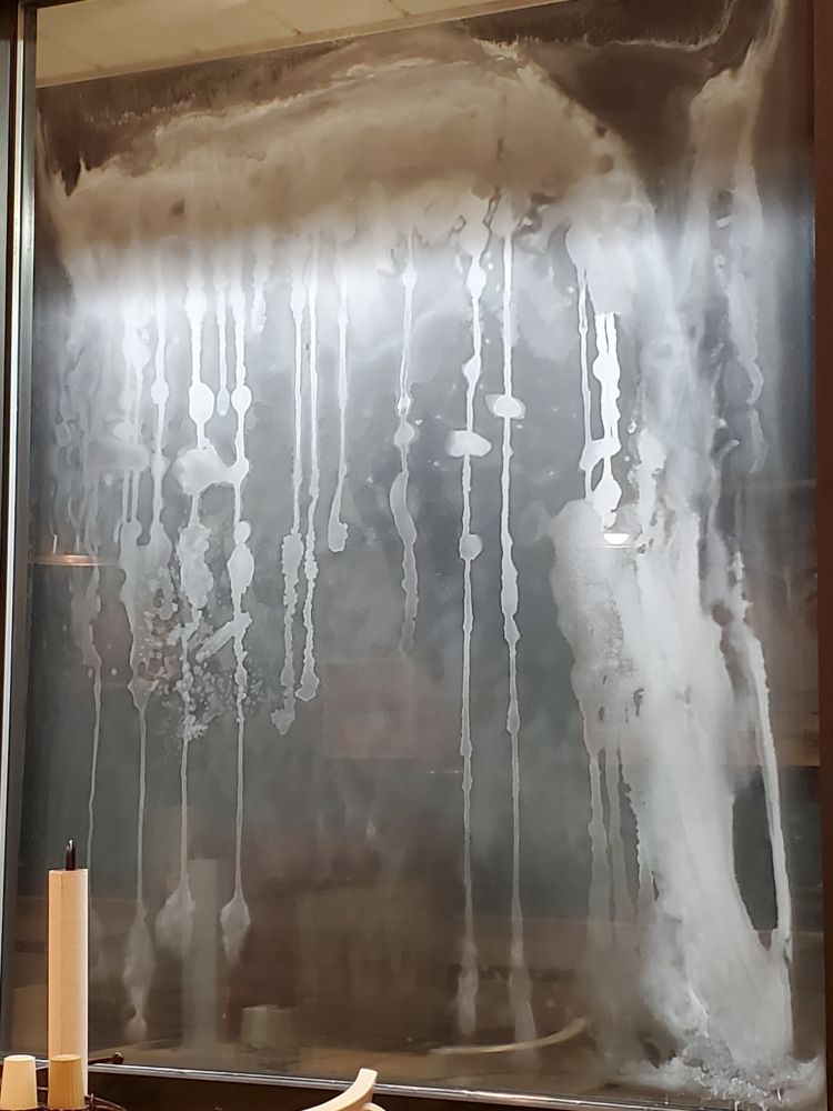 A double-pane window with years of dried condensation between the panes, making the window nearly opaque. 