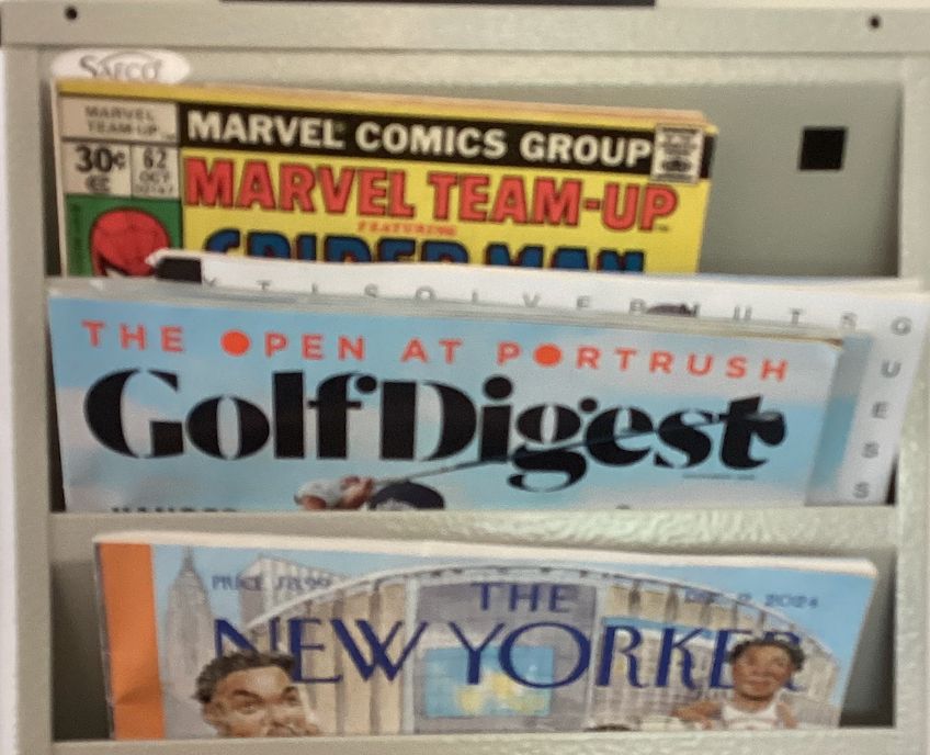 magazine rack at a doctor's office, photo taken in 2025, with recent issues of Golf Digest and The New Yorker visible, but also Marvel Team-Up Vol. 1 #77 (Spider-Man and Ms. Marvel, release date July 26th, 1977) for some reason.