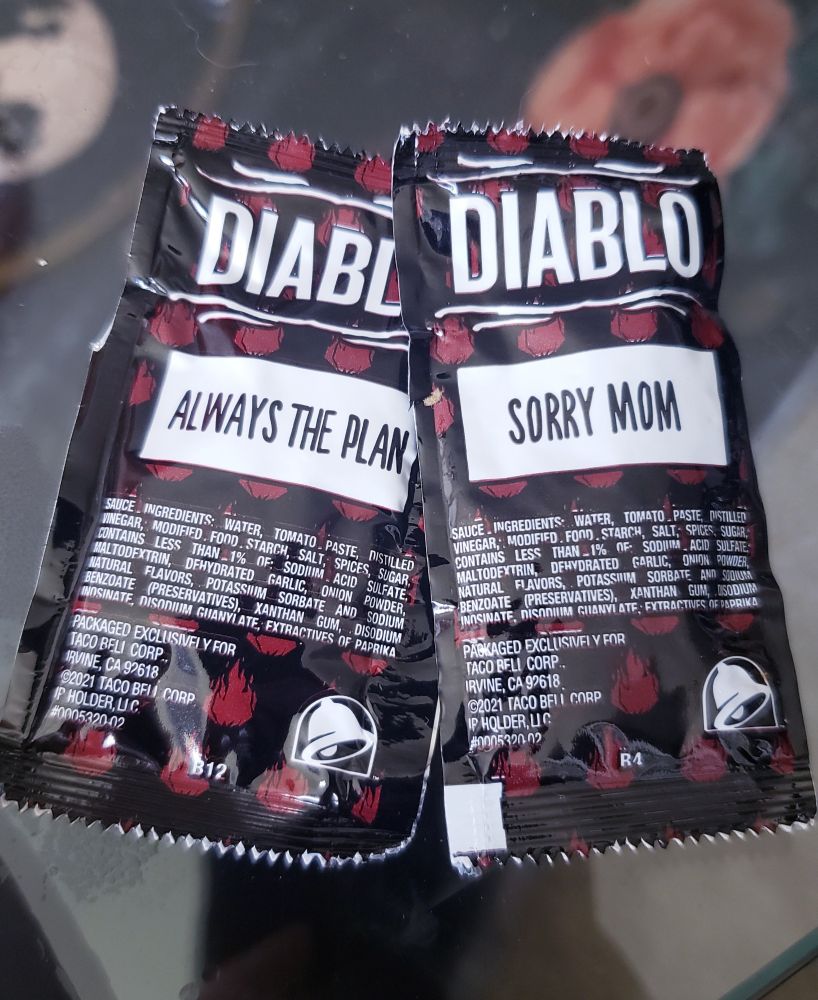 a pair of Diablo hot sauce packets from taco bell. they have funny little phrases on them, but these two say "always the plan" and "sorry mom"