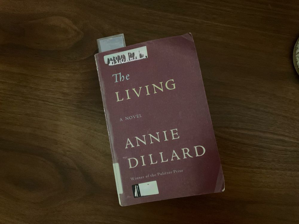 book laying askew on wood desktop:

The
LIVING

A NOVEL

ANNIE
DILLARD
