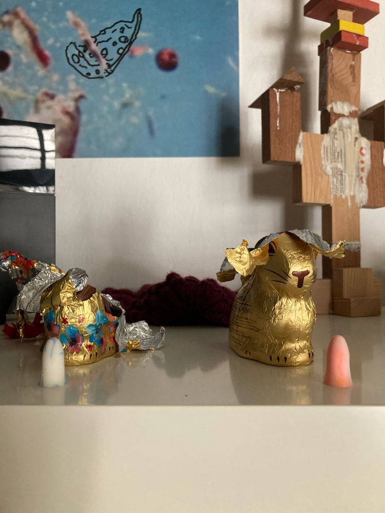 zwei halb aufgegessene Schoko-Osterhasen stehen auf einem Regal