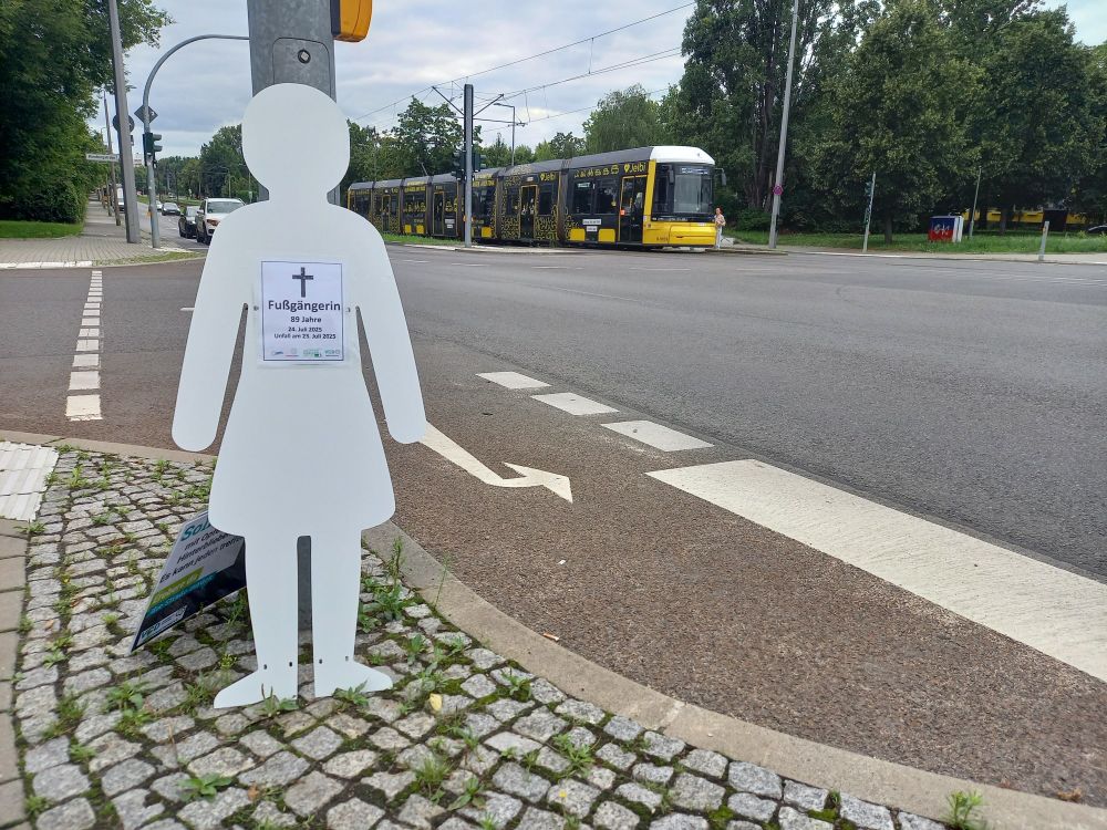 Mahnwachen-Figur vor Straßenbahn