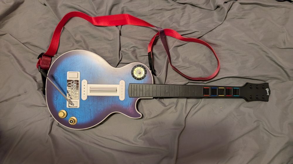 an image of the CRKD Blueberry Burst Pro Guitar, Multiplatform edition with the pre-order bonus gradient guitar strap