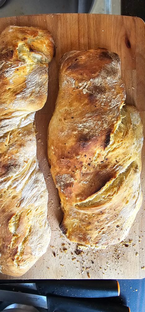 Freshly baked baguettes, out of the oven on wooden board 