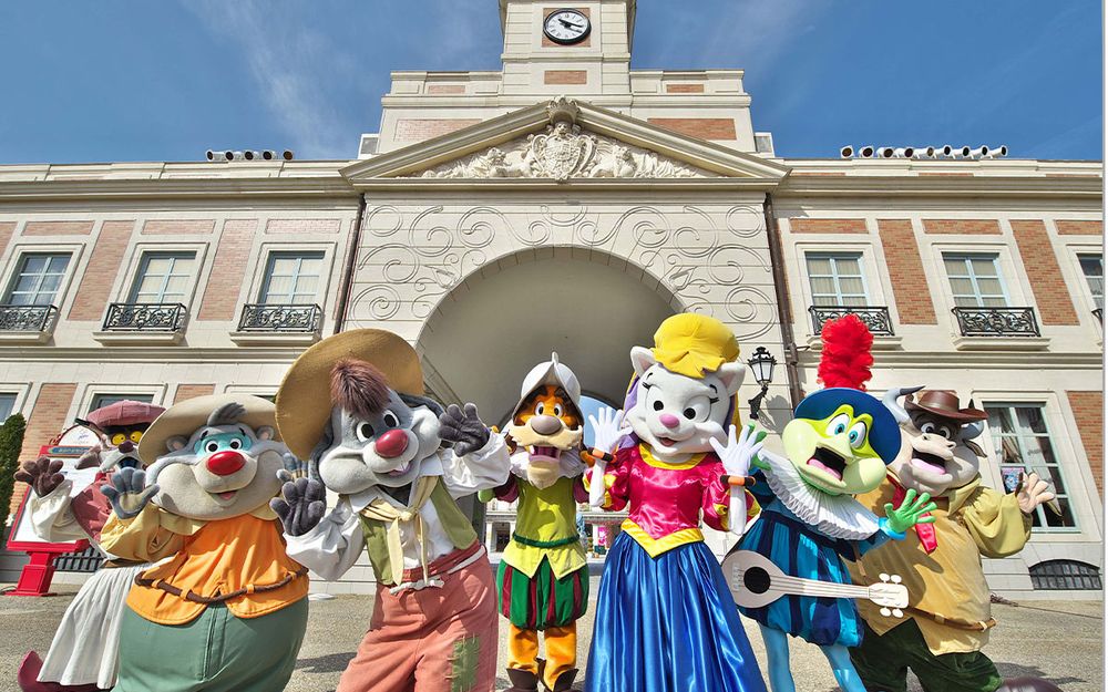 The mascots of Shima Spain Village, a japanese theme park themed after the country of Spain. They are posing in front of the park's entrance, a mix between Madrid's Plaza Mayor and Puerta del Sol, for some reason.